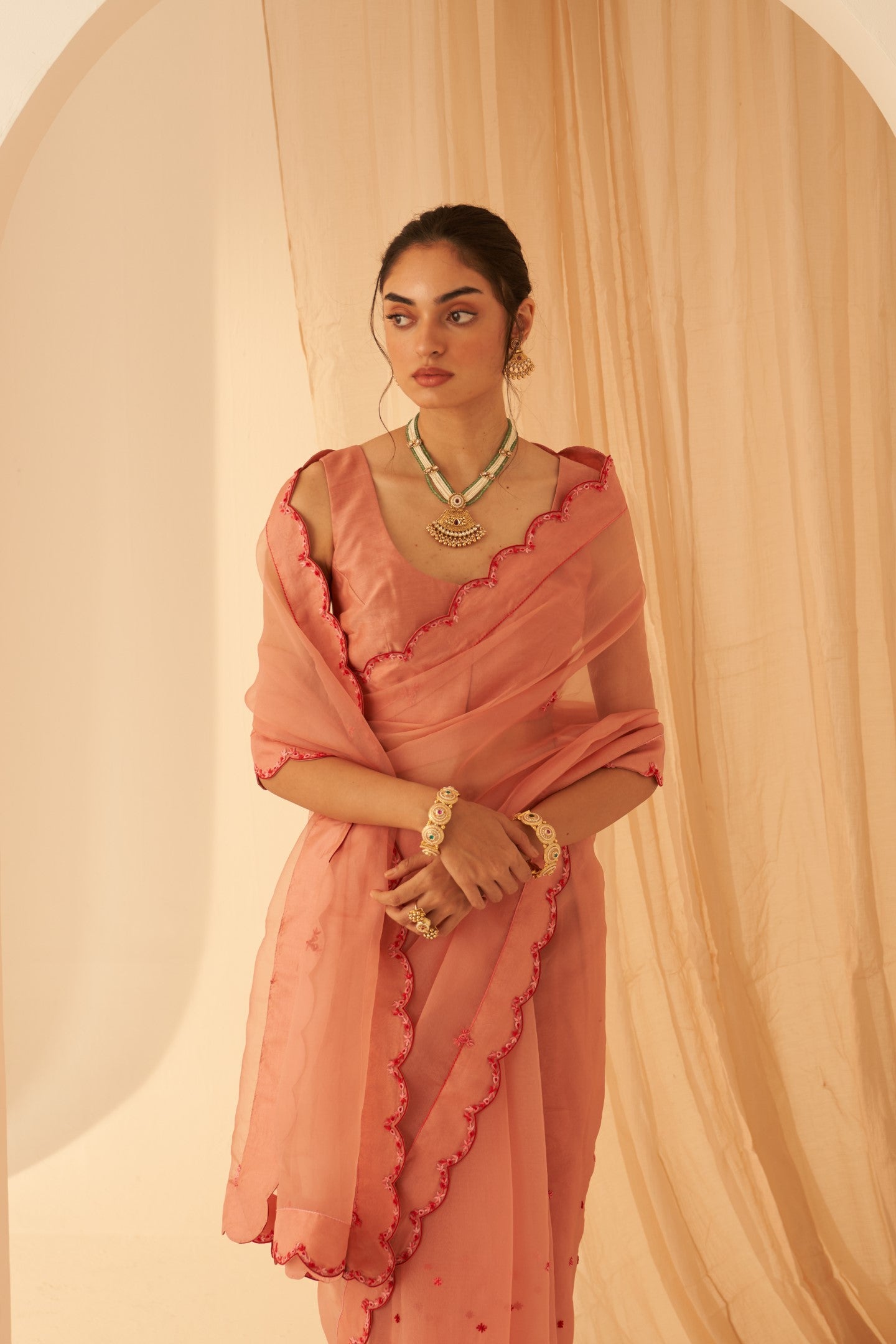 Peach organza aari hand embroidered saree with beautiful butis allover & scallop border paired with an organic cotton stitched petticoat